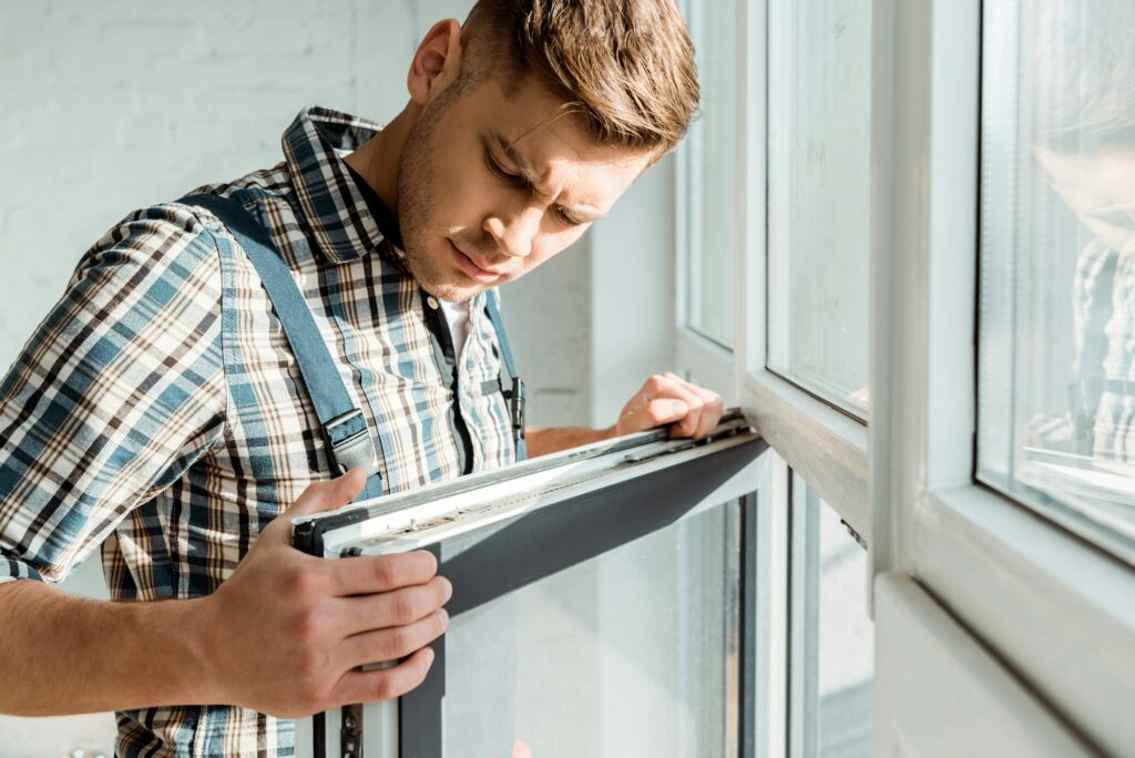 selective focus of handsome installer touching window